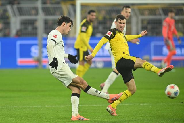 19 December 2025, North Rhine-Westphalia, Dortmund: Gladbach's Gio Reyna and Dortmund's Pascal Gross(R) battle for the ball during the German Bundesliga soccer match between Borussia Dortmund and Borussia Moenchengladbach at the Signal Iduna Park. Photo: Bernd Thissen/dpa