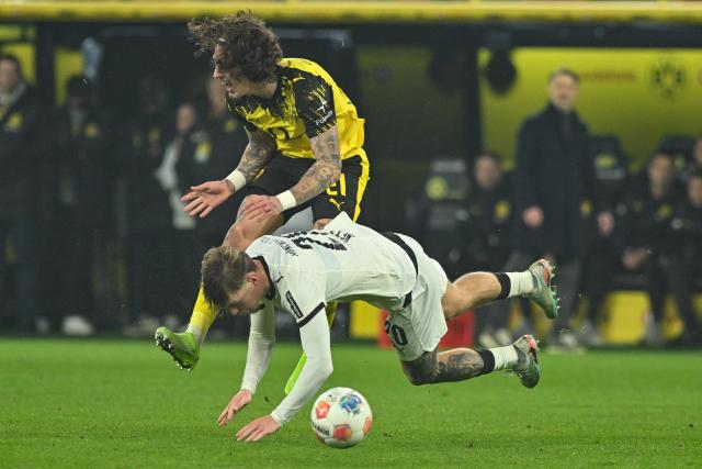 19 December 2025, North Rhine-Westphalia, Dortmund: Dortmund's Fabio Silva and Gladbach's Luca Netz in action during the German Bundesliga soccer match between Borussia Dortmund and Borussia Moenchengladbach at the Signal Iduna Park. Photo: Bernd Thissen/dpa