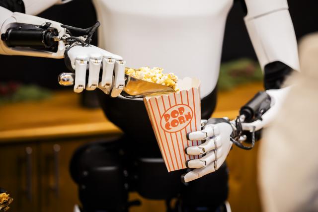 20 December 2025, Berlin: Tesla's humanoid robot 'Optimus' distributes popcorn at a Christmas market stall during a public presentation at the Mall of Berlin. Photo: Christoph Soeder/dpa