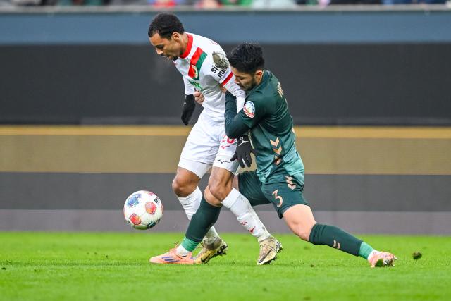 20 December 2025, Bavaria, Augsburg: Augsburg's Alexis Claude-Maurice (L) and Werder Bremen's Yukinari Sugawara battle for the ball during the German Bundesliga soccer match between FC Augsburg and Werder Bremen at WWK-Arena. Photo: Harry Langer/dpa - WICHTIGER HINWEIS: Gemäß den Vorgaben der DFL Deutsche Fußball Liga bzw. des DFB Deutscher Fußball-Bund ist es untersagt, in dem Stadion und/oder vom Spiel angefertigte Fotoaufnahmen in Form von Sequenzbildern und/oder videoähnlichen Fotostrecken zu verwerten bzw. verwerten zu lassen.