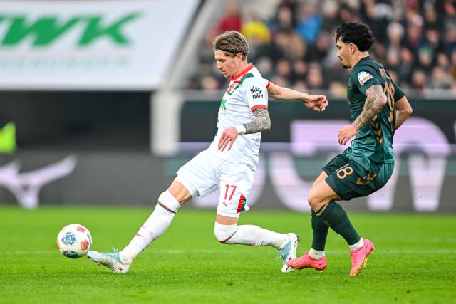 20 December 2025, Bavaria, Augsburg: Augsburg's Kristijan Jakie (L) and Werder Bremen's Cameron Puertas battle for the ball during the German Bundesliga soccer match between FC Augsburg and Werder Bremen at WWK-Arena. Photo: Harry Langer/dpa - WICHTIGER HINWEIS: Gemäß den Vorgaben der DFL Deutsche Fußball Liga bzw. des DFB Deutscher Fußball-Bund ist es untersagt, in dem Stadion und/oder vom Spiel angefertigte Fotoaufnahmen in Form von Sequenzbildern und/oder videoähnlichen Fotostrecken zu verwerten bzw. verwerten zu lassen.