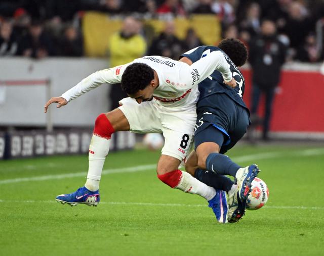 20 December 2025, Baden-Wuerttemberg, Stuttgart: Stuttgart's Tiago Tomas (L) and Hoffenheim's Bernardo battle for the ball during the German Bundesliga soccer match between VfB Stuttgart and TSG 1899 Hoffenheim at MHPArena. Photo: Uli Deck/dpa - WICHTIGER HINWEIS: Gemäß den Vorgaben der DFL Deutsche Fußball Liga bzw. des DFB Deutscher Fußball-Bund ist es untersagt, in dem Stadion und/oder vom Spiel angefertigte Fotoaufnahmen in Form von Sequenzbildern und/oder videoähnlichen Fotostrecken zu verwerten bzw. verwerten zu lassen.