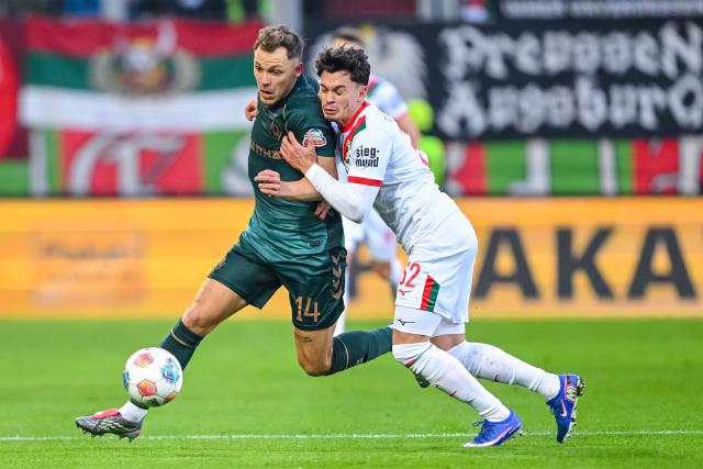 20 December 2025, Bavaria, Augsburg: Werder Bremen's Senne Lynen (L) and Augsburg's Fabian Rieder battle for the ball during the German Bundesliga soccer match between FC Augsburg and Werder Bremen at WWK-Arena. Photo: Harry Langer/dpa - WICHTIGER HINWEIS: Gemäß den Vorgaben der DFL Deutsche Fußball Liga bzw. des DFB Deutscher Fußball-Bund ist es untersagt, in dem Stadion und/oder vom Spiel angefertigte Fotoaufnahmen in Form von Sequenzbildern und/oder videoähnlichen Fotostrecken zu verwerten bzw. verwerten zu lassen.