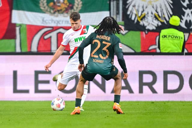 20 December 2025, Bavaria, Augsburg: Augsburg's Robin Fellhauer (L) and Werder Bremen's Isaac Schmidt battle for the ball during the German Bundesliga soccer match between FC Augsburg and Werder Bremen at WWK-Arena. Photo: Harry Langer/dpa - WICHTIGER HINWEIS: Gemäß den Vorgaben der DFL Deutsche Fußball Liga bzw. des DFB Deutscher Fußball-Bund ist es untersagt, in dem Stadion und/oder vom Spiel angefertigte Fotoaufnahmen in Form von Sequenzbildern und/oder videoähnlichen Fotostrecken zu verwerten bzw. verwerten zu lassen.