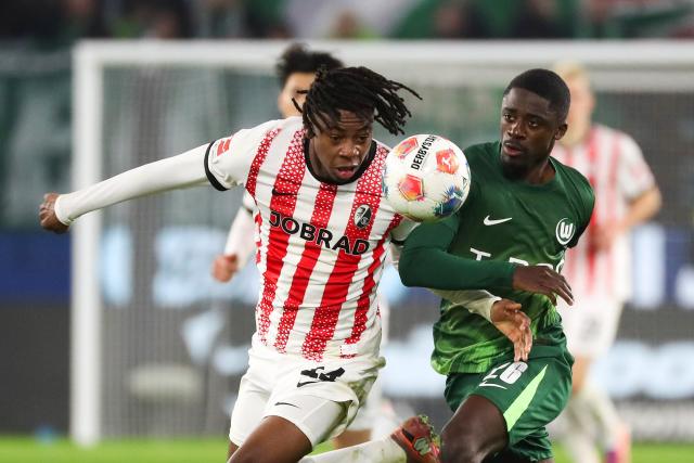 20 December 2025, Lower Saxony, Wolfsburg: Freiburg's Johan Manzambi (L) and Wolfsburg's Sael Kumbedi battle for the ball during the German Bundesliga soccer match between VfL Wolfsburg and SC Freiburg at Volkswagen Arena. Photo: Darius Simka/dpa - WICHTIGER HINWEIS: Gemäß den Vorgaben der DFL Deutsche Fußball Liga bzw. des DFB Deutscher Fußball-Bund ist es untersagt, in dem Stadion und/oder vom Spiel angefertigte Fotoaufnahmen in Form von Sequenzbildern und/oder videoähnlichen Fotostrecken zu verwerten bzw. verwerten zu lassen.