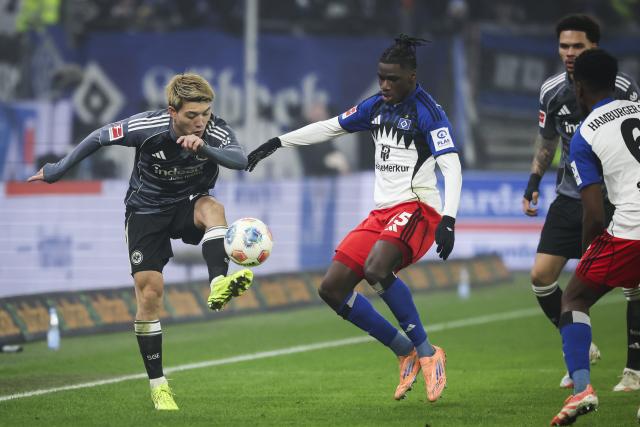 20 December 2025, Hamburg: Eintracht Frankfurt's Ritsu Doan (L) and Hamburger's Fabio Balde battle for the ball during the German Bundesliga soccer match between Hamburger SV and Eintracht Frankfurt at Volksparkstadion. Photo: Christian Charisius/dpa - WICHTIGER HINWEIS: Gemäß den Vorgaben der DFL Deutsche Fußball Liga bzw. des DFB Deutscher Fußball-Bund ist es untersagt, in dem Stadion und/oder vom Spiel angefertigte Fotoaufnahmen in Form von Sequenzbildern und/oder videoähnlichen Fotostrecken zu verwerten bzw. verwerten zu lassen.