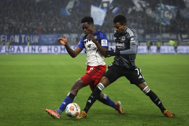 20 December 2025, Hamburg: Eintracht Frankfurt's Ansgar Knauff (R) and Hamburger's Albert Lokonga battle for the ball during the German Bundesliga soccer match between Hamburger SV and Eintracht Frankfurt at Volksparkstadion. Photo: Christian Charisius/dpa - WICHTIGER HINWEIS: Gemäß den Vorgaben der DFL Deutsche Fußball Liga bzw. des DFB Deutscher Fußball-Bund ist es untersagt, in dem Stadion und/oder vom Spiel angefertigte Fotoaufnahmen in Form von Sequenzbildern und/oder videoähnlichen Fotostrecken zu verwerten bzw. verwerten zu lassen.