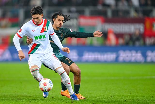 20 December 2025, Bavaria, Augsburg: Augsburg's Fabian Rieder (L) and Werder Bremen's Isaac Schmidt battle for the ball during the German Bundesliga soccer match between FC Augsburg and Werder Bremen at WWK-Arena. Photo: Harry Langer/dpa - WICHTIGER HINWEIS: Gemäß den Vorgaben der DFL Deutsche Fußball Liga bzw. des DFB Deutscher Fußball-Bund ist es untersagt, in dem Stadion und/oder vom Spiel angefertigte Fotoaufnahmen in Form von Sequenzbildern und/oder videoähnlichen Fotostrecken zu verwerten bzw. verwerten zu lassen.