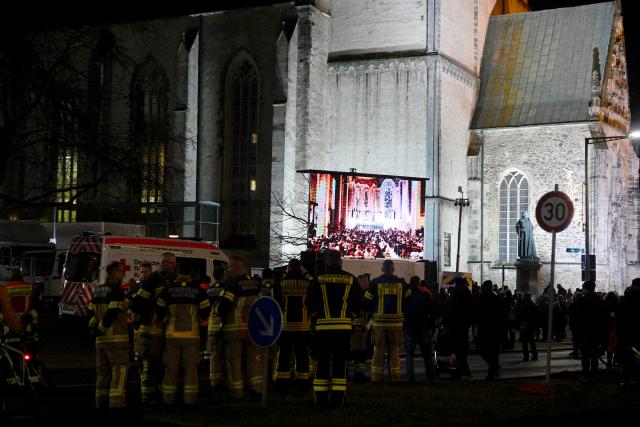 20 December 2025, Saxony-Anhalt, Magdeburg: People gather in front of St. John's Church and watch the memorial service on a screen one year after the attack on Magdeburg's Christmas market. On 20 December 2024, a man drove a car into a crowd, killing five women and a child and injuring more than 300 people. Photo: Klaus-Dietmar Gabbert/dpa