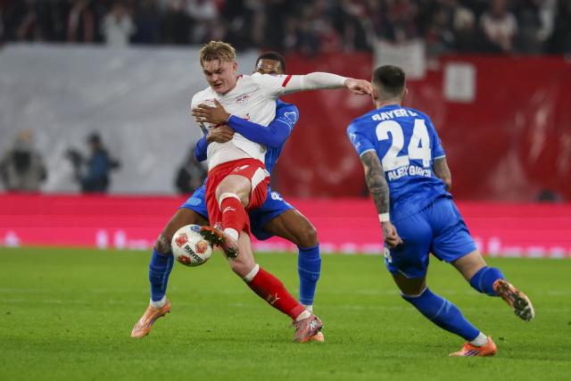 20 December 2025, Saxony, Leipzig: Leipzig's Conrad Harder (L) and Bayer Leverkusen's Jeanuel Belocian battle for the ball during the German Bundesliga soccer match between RB Leipzig and Bayer Leverkusen at Red Bull Arena. Photo: Jan Woitas/dpa - WICHTIGER HINWEIS: Gemäß den Vorgaben der DFL Deutsche Fußball Liga bzw. des DFB Deutscher Fußball-Bund ist es untersagt, in dem Stadion und/oder vom Spiel angefertigte Fotoaufnahmen in Form von Sequenzbildern und/oder videoähnlichen Fotostrecken zu verwerten bzw. verwerten zu lassen.