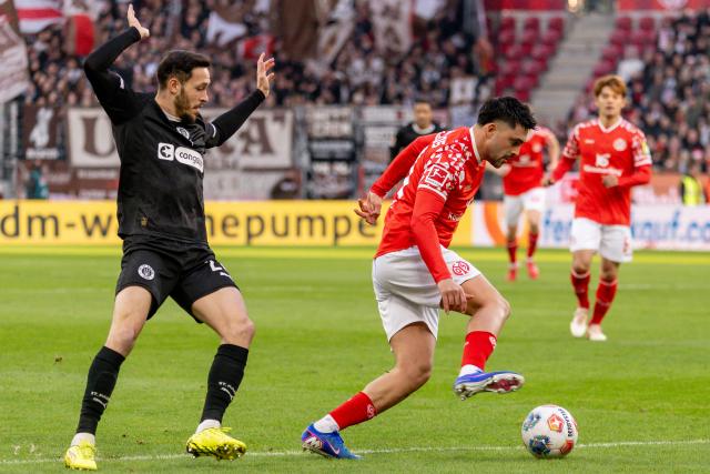21 December 2025, Rhineland-Palatinate, Mainz: FSV Mainz's Nadiem Amiri (R) and St. Pauli's Mathias Pereira Lage battle for the ball during the German Bundesliga soccer match between FSV Mainz 05 and FC St. Pauli at Mewa Arena. Photo: Torsten Silz/dpa - WICHTIGER HINWEIS: Gemäß den Vorgaben der DFL Deutsche Fußball Liga bzw. des DFB Deutscher Fußball-Bund ist es untersagt, in dem Stadion und/oder vom Spiel angefertigte Fotoaufnahmen in Form von Sequenzbildern und/oder videoähnlichen Fotostrecken zu verwerten bzw. verwerten zu lassen.