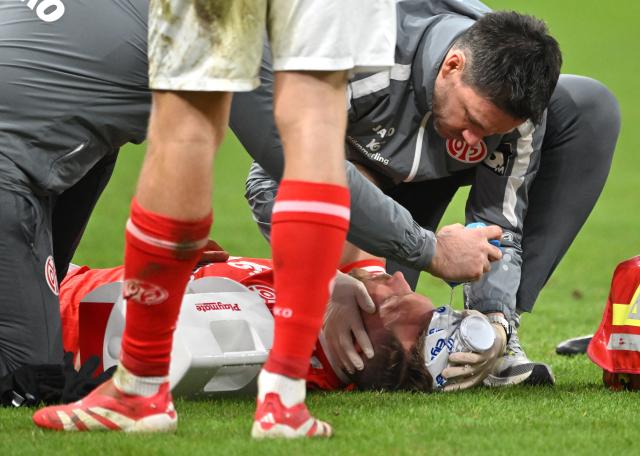 21 December 2025, Rhineland-Palatinate, Mainz: FSV Mainz Silvan Widmer receives treatment on the ground during the German Bundesliga soccer match between FSV Mainz 05 and FC St. Pauli at Mewa Arena. Photo: Torsten Silz/dpa - WICHTIGER HINWEIS: Gemäß den Vorgaben der DFL Deutsche Fußball Liga bzw. des DFB Deutscher Fußball-Bund ist es untersagt, in dem Stadion und/oder vom Spiel angefertigte Fotoaufnahmen in Form von Sequenzbildern und/oder videoähnlichen Fotostrecken zu verwerten bzw. verwerten zu lassen.