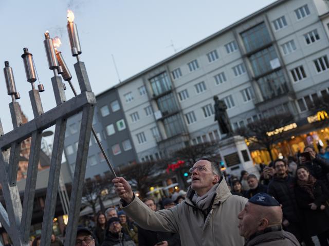 21 December 2025, Rhineland-Palatinate, Mainz: Minister of the Interior of Rhineland-Palatinate Michael Ebling lights a candle on a Hanukkia at the annual joint candle-lighting ceremony for Hanukkah orgnized by The state association of Jewish communities in Rhineland-Palatinate. Photo: Hannes P. Albert/dpa