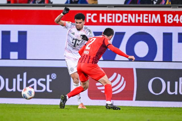 21 December 2025, Baden-Wuerttemberg, Heidenheim: Bayern Munich's Luis Diaz (L) and Heidenheim's Marnon Busch battle for the ball during the German Bundesliga soccer match between 1. FC Heidenheim and Bayern Munich at Voith-Arena. Photo: Harry Langer/dpa - WICHTIGER HINWEIS: Gemäß den Vorgaben der DFL Deutsche Fußball Liga bzw. des DFB Deutscher Fußball-Bund ist es untersagt, in dem Stadion und/oder vom Spiel angefertigte Fotoaufnahmen in Form von Sequenzbildern und/oder videoähnlichen Fotostrecken zu verwerten bzw. verwerten zu lassen.