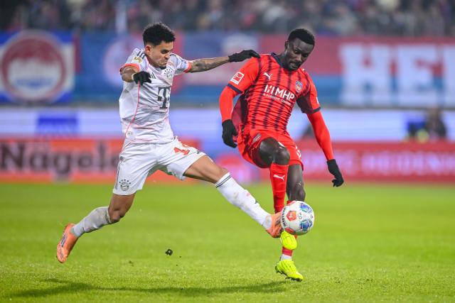 21 December 2025, Baden-Wuerttemberg, Heidenheim: Bayern Munich's Luis Diaz (L) and Heidenheim's Sirlord Conteh battle for the ball during the German Bundesliga soccer match between 1. FC Heidenheim and Bayern Munich at Voith-Arena. Photo: Harry Langer/dpa - WICHTIGER HINWEIS: Gemäß den Vorgaben der DFL Deutsche Fußball Liga bzw. des DFB Deutscher Fußball-Bund ist es untersagt, in dem Stadion und/oder vom Spiel angefertigte Fotoaufnahmen in Form von Sequenzbildern und/oder videoähnlichen Fotostrecken zu verwerten bzw. verwerten zu lassen.