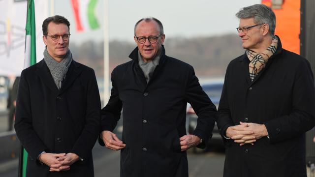 22 December 2025, North Rhine-Westphalia, Lüdenscheid: Hendrik Wuest (L-R), Minister President of North Rhine-Westphalia, German Chancellor Friedrich Merz and German Transport Minister Patrick Schnieder at the opening of the Rahmedetal Bridge. The important A45 north-south axis in the Sauerland region was interrupted for almost four years due to a dilapidated bridge. The dilapidated bridge was closed at the beginning of December 2021 and later blown up. Photo: Rolf Vennenbernd/dpa