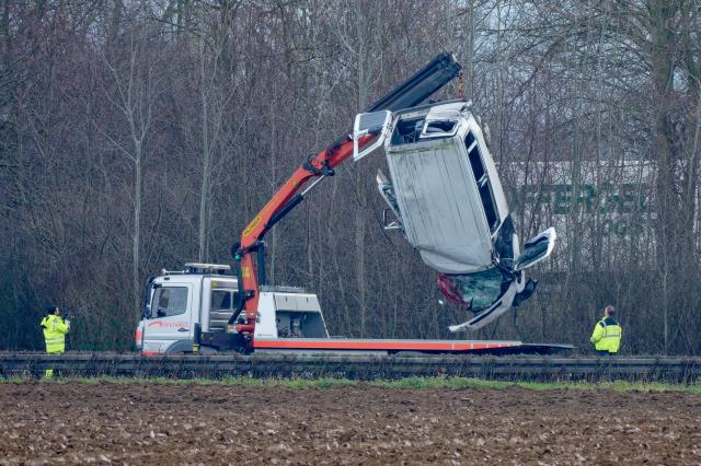 22 December 2025, North Rhine-Westphalia, Jülich: The wreckage of a van is lifted onto a tow truck after a serious accident on the A44 highway. Two people were killed and four injured in the serious traffic accident. Photo: Henning Kaiser/dpa - ATTENTION: License plate has been pixelated for legal reasons
