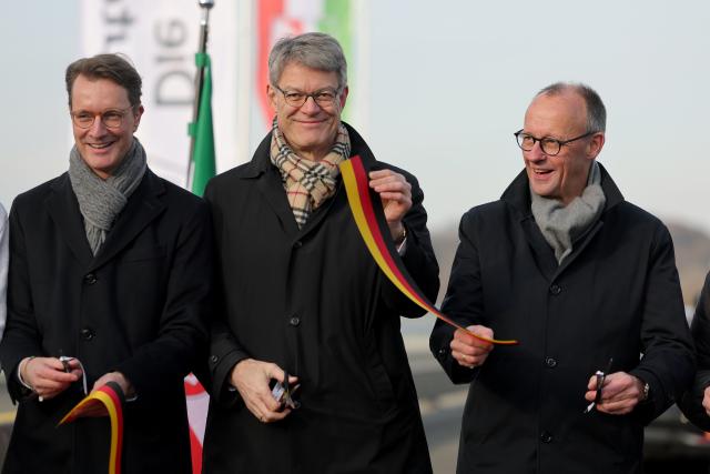 22 December 2025, North Rhine-Westphalia, Lüdenscheid: Hendrik Wuest (L-R), Minister President of North Rhine-Westphalia, Federal Transport Minister Patrick Schnieder and German Chancellor Friedrich Merz cut a ribbon at the opening of the Rahmedetal Bridge. The important A45 north-south axis in the Sauerland region was interrupted for almost four years due to a dilapidated bridge. The dilapidated bridge was closed at the beginning of December 2021 and later blown up. Photo: Rolf Vennenbernd/dpa