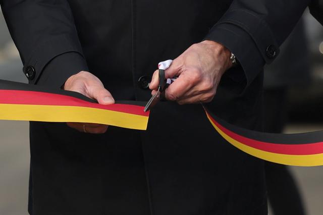 22 December 2025, North Rhine-Westphalia, Luedenscheid: German Chancellor Friedrich Merz cuts a ribbon at the opening of the Rahmedetal bridge. The important A45 north-south axis in the Sauerland region was interrupted for almost four years due to a dilapidated bridge. The dilapidated bridge was closed at the beginning of December 2021 and later blown up. Photo: Rolf Vennenbernd/dpa