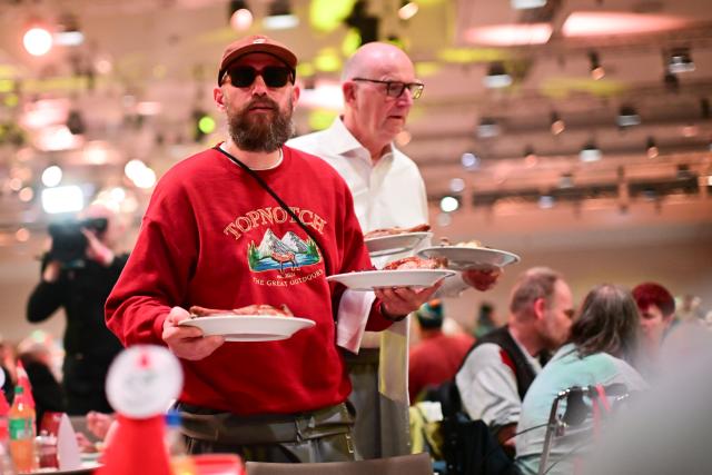 22 December 2025, Berlin: German rapper MC Fitti serves food in front of Minister President of Brandenburg Dietmar Woidke during Frank Zander's 31st Christmas party for the homeless and needy at the Estrel Hotel in Berlin. Photo: Sebastian Christoph Gollnow/dpa