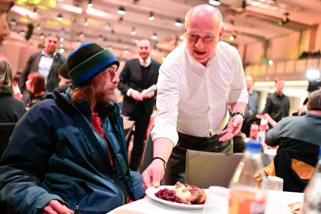 22 December 2025, Berlin: Governing Mayor of Berlin Kai Wegner (R) serves food to Berlin's homeless during Frank Zander's 31st Christmas party for the homeless and needy at the Estrel Hotel. Photo: Sebastian Christoph Gollnow/dpa