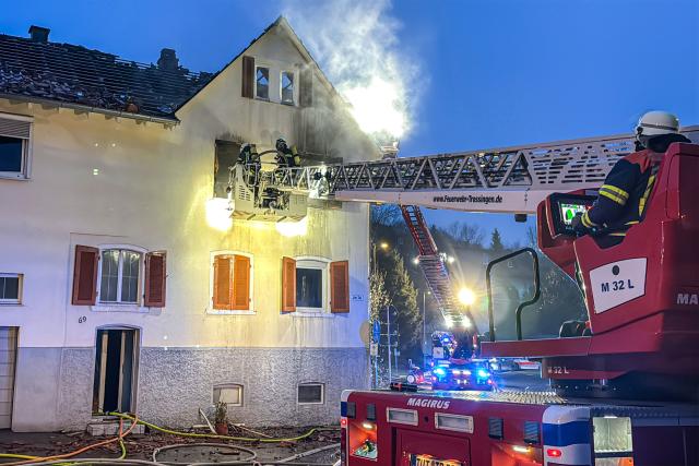 23 December 2025, Baden-Württemberg, Trossingen: Firefighters fight a building fire in the Tuttlingen district. During the course of the operation, the emergency services found a body in the building, according to a police spokesperson. The extinguishing work and police investigations are ongoing. Photo: Christian Klemm/onw-images/dpa