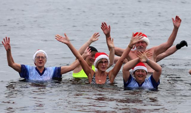 24 December 2025, Brandenburg, Senftenberg: The members of the Pirrlliepausen (North German for icicles) winter swimming club gather for their traditional Christmas swim in Lake Senftenberg. Photo: Bernd Wüstneck/dpa