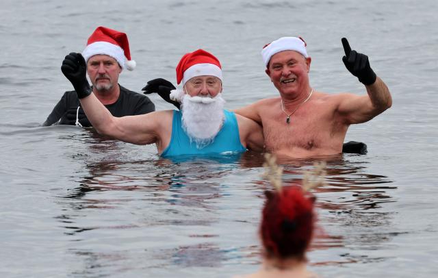24 December 2025, Brandenburg, Senftenberg: The members of the Pirrlliepausen (North German for icicles) winter swimming club gather for their traditional Christmas swim in Lake Senftenberg. Photo: Bernd Wüstneck/dpa