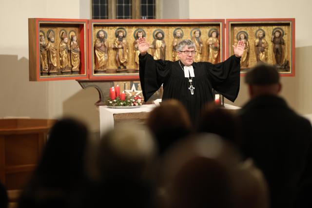 24 December 2025, Thuringia, Rohnstedt: Bishop Friedrich Kramer blesses the visitors to Christmas Vespers on Christmas Eve. Photo: Matthias Bein/dpa