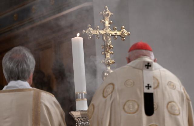 24 December 2025, Bavaria, Munich: Cardinal Reinhard Marx stands in front of a cross during Christmas mass in Munich Cathedral. This Christmas service takes place every year in the Frauenkirche. Photo: Felix Hörhager/dpa