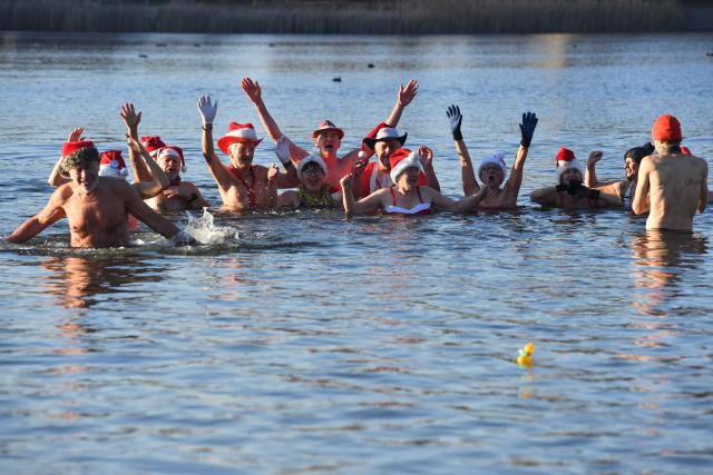 25 December 2025, Berlin: Numerous water enthusiasts brave sub-zero temperatures during the Christmas swim organized by the Berlin Seal Club at Orankesee. With the water at just under one degree Celsius, participants are only able to remain in the lake for a short time. Photo: Paul Zinken/dpa