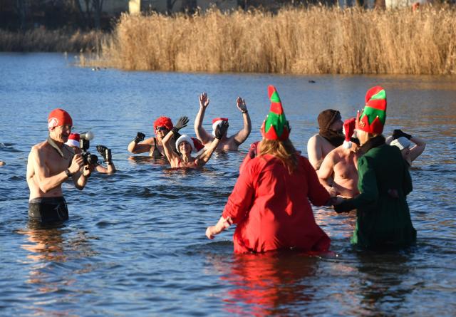 25 December 2025, Berlin: Numerous water enthusiasts brave sub-zero temperatures during the Christmas swim organized by the Berlin Seal Club at Orankesee. With the water at just under one degree Celsius, participants are only able to remain in the lake for a short time. Photo: Paul Zinken/dpa