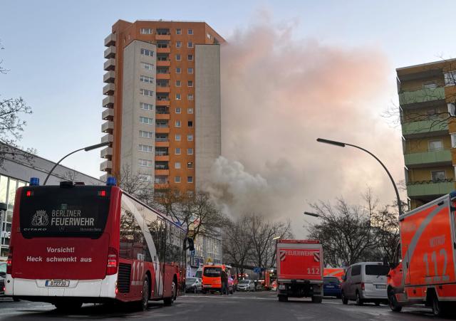 28 December 2025, Berlin: Emergency vehicles from the rescue services and fire department stand in front of a high-rise building after a fire broke out in Berlin-Spandau. At least three people have been injured and more than 100 firefighters are on duty. Photo: Sven Käuler/dpa