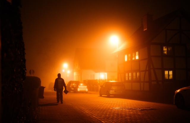 28 December 2025, Lower Saxony, Laatzen: A man walks across a road in the Hanover region in fog and below-freezing temperatures. Fog, frost and freezing rain have once again made the roads slippery. Photo: Julian Stratenschulte/dpa