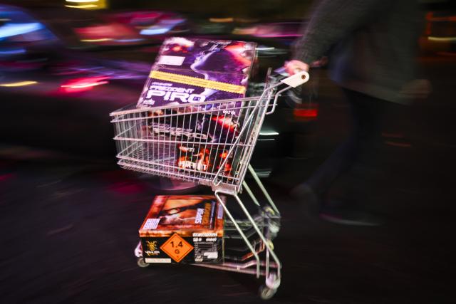 29 December 2025, Hamburg: A customer with a full shopping cart walks across the parking lot during a special sale of fireworks in the clubhouse of a shooting club in Hamburg-Harburg. The sale of New Year's Eve fireworks begins today in Germany. Photo: Christian Charisius/dpa