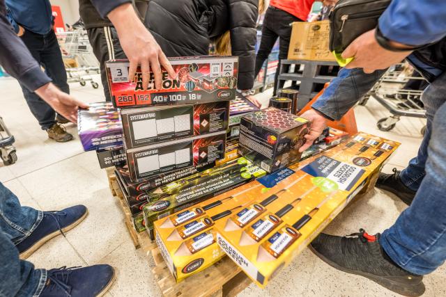 29 December 2025, Brandenburg, Cottbus: Customers collect fireworks directly from a trolley at a supermarket in Cottbus. The sale of New Year's Eve fireworks begins today in Germany. Photo: Frank Hammerschmidt/dpa