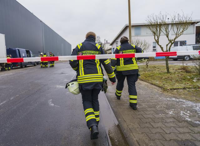 29 December 2025, Hesse, Mainhausen: Firefighters go to the scene in front of the affected building complex in the Offenbach district after a fire in a commercial building complex in Mainhausen-Zellhausen. The police assume that a 64-year-old man did not survive the fire, as they reported. The police put the damage at around three million euros. Photo: Andreas Arnold/dpa - ATTENTION: Company logo(s) have been pixelated for legal reasons