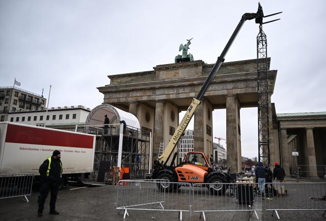 29 December 2025, Berlin: Workers set up installations at the Brandenburg Gate during preparations for the New Year's Eve event in Berlin. Due to the planned celebrations, parts of Strasse des 17. Juni are closed. Photo: Britta Pedersen/dpa