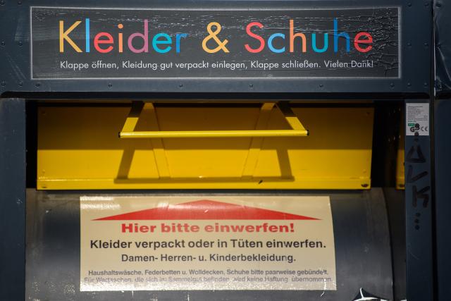 FILED - 25 November 2025, Saxony-Anhalt, Magdeburg: Close-up of a clothing container with the inscription "Clothes & Shoes" and instructions for depositing well-packed women's, men's and children's clothing and shoes bundled in pairs. Photo: Klaus-Dietmar Gabbert/dpa