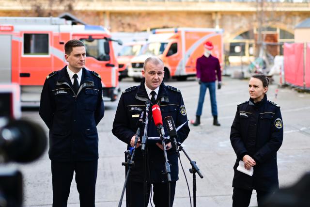 30 December 2025, Berlin: Vinzenz Kasch (C), Head of Communications and spokesperson for the Berlin Fire Department, speaks during the Berlin Fire Department's press conference "Celebrating safely together: New Year's Eve 2025/2026" alongside Markus Wiezorek (l), Head of the Firefighting/Technical Assistance Department of the Berlin Fire Department, and Jessica Lotze, Senior Physician at the Berlin Fire Department. Photo: Sebastian Christoph Gollnow/dpa