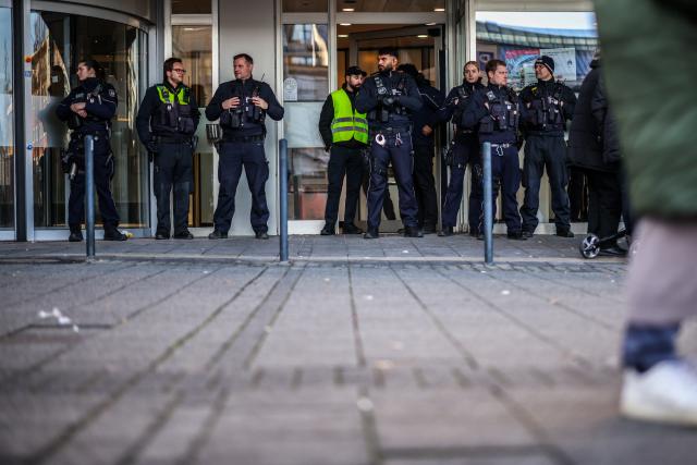 30 December 2025, North Rhine-Westphalia, Gelsenkirchen: Police officers stand in front of the savings bank branch in the Buer district. After the break-in into the bank's vault, worried customers are demanding information. Due to the situation, the branch will remain closed on Tuesday, according to the police. Photo: Christoph Reichwein/dpa