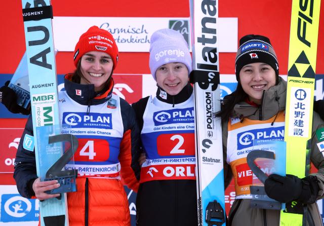31 December 2025, Bavaria, Garmisch-Partenkirchen: Germany's Selina Freitag (second, l-r), Slovenia's Nika Prevc and Japan's Nozomi Maruyama stand at the award ceremony. Nordic skiing/ski jumping, World Cup, Two-Nights-Tour, large hill, women, 2nd round. Photo: Karl-Josef Hildenbrand/dpa