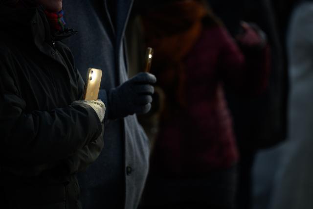 31 December 2025, Hamburg: Participants hold up their mobile phones with flashlights switched on during a chain of lights around the Outer Alster under the motto "Hamburg togetHHer," calling for solidarity and against loneliness. Photo: Jonas Walzberg/dpa
