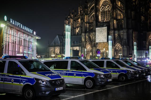 31 December 2025, North Rhine-Westphalia, Cologne: Police vehicles park in a parking lot at the exit of the main train station near Cologne Cathedral. Photo: Christoph Reichwein/dpa