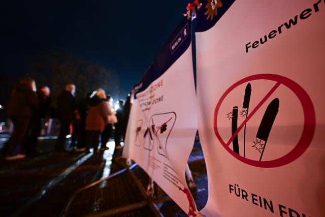 31 December 2025, Berlin: Passers-by stand at a checkpoint at the entrance to the pyrotechnics ban zone on Alexanderplatz during New Year's Eve. At the turn of the year, there are four firecracker ban zones in Berlin in which, in addition to a ban on fireworks and firecrackers, the carrying of knives and weapons is also prohibited. Photo: Sebastian Christoph Gollnow/dpa