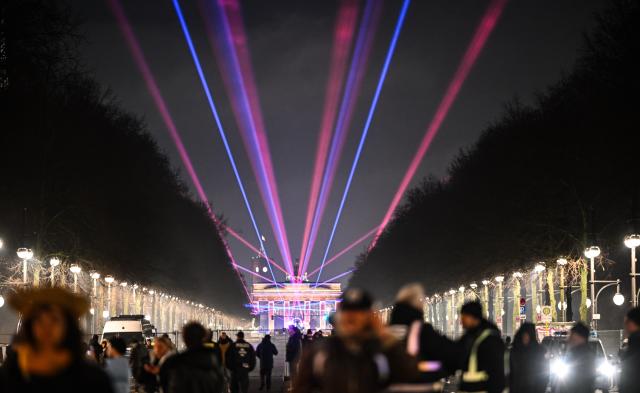 31 December 2025, Berlin: Lasers light up the sky above 17 June Street towards the Brandenburg Gate during the "WeAreBerlin" party. Photo: Britta Pedersen/dpa