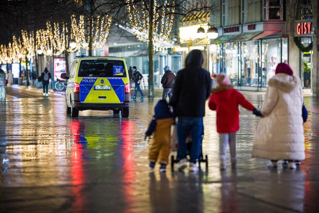 31 December 2025, Lower Saxony, Hanover: A police emergency vehicle drives through the city center on New Year's Eve in rainy weather. Photo: Moritz Frankenberg/dpa