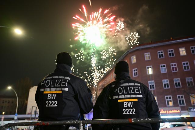 31 December 2025, Berlin: Police officers watch for fireworks being set off just outside the prohibited zone on Sonnenallee on New Year's Eve. At the turn of the year, Berlin has four firecracker ban zones in which, in addition to a ban on fireworks and firecrackers, the carrying of knives and weapons is also prohibited. Photo: Sebastian Christoph Gollnow/dpa