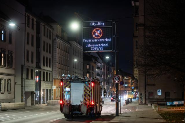 31 December 2025, Baden-Württemberg, Stuttgart: A fire department emergency vehicle drives past a display board informing about the New Year's Eve fireworks ban in the city center. Photo: Silas Stein/dpa