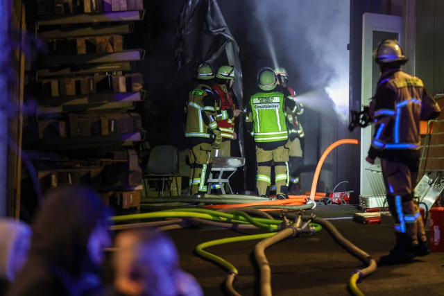 01 January 2026, North Rhine-Westphalia, Solingen: Firefighters work at the entrance to a warehouse during a fire on New Year's Eve. Photo: Christoph Reichwein/dpa